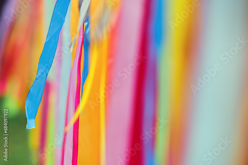 Картината върху платно A row of colorful ribbons hang and sway in the wind, creating a vibrant scene in