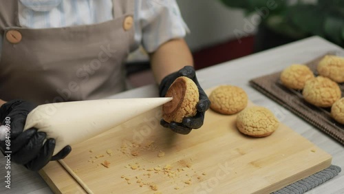 The chef is filling the inside of the choux cream with vanilla cream, Bakery making concept