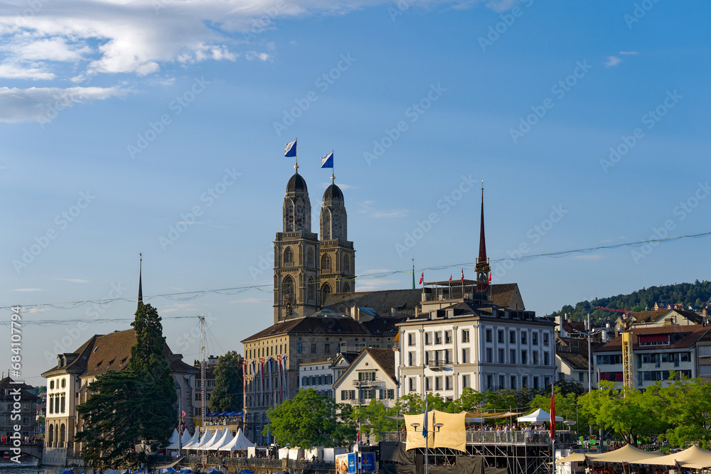 Twin towers with flags of City of Zürich and Canton Zürich on top of church towers of protestant church Great Minster on a sunny summer evening. Photo taken July 7th, 2023, Zurich, Switzerland.