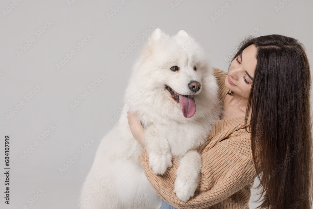 girl playing and hugging a white Samoyed dog on a clean white background, caring for a dog, large white dog girl playing and hugging a white Samoyed dog on a clean white background, caring for a dog, large white dog