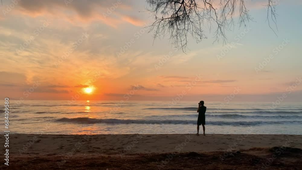 people activity concept with moving of wave and asian man use camera take picture on sand beach with sea background people activity concept with moving of wave and asian man use camera take picture on sand beach with sea background