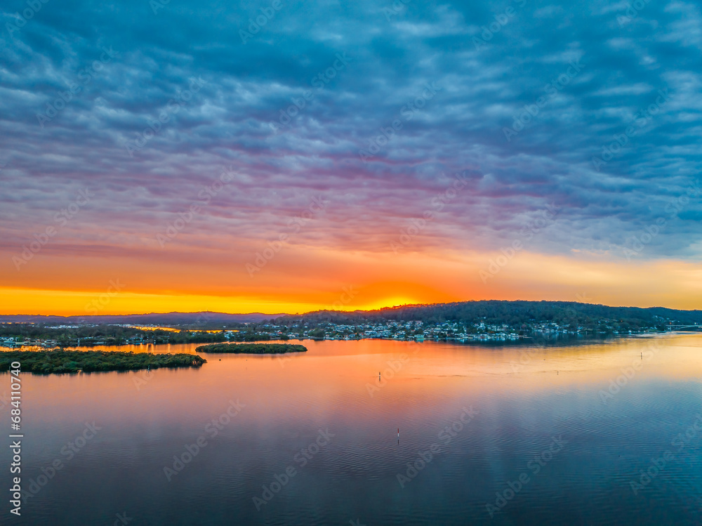 Heavy cloud covered sunrise over the bay with colour and reflections