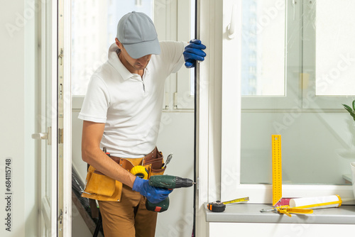 фотографія a repairman repairs, adjusts or installs metal-plastic windows in the apartment