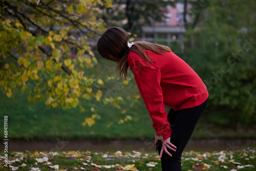 Athletic young woman taking a breath and relaxing after jogging and stretching. Woman Training and Workout Exercises On Street.