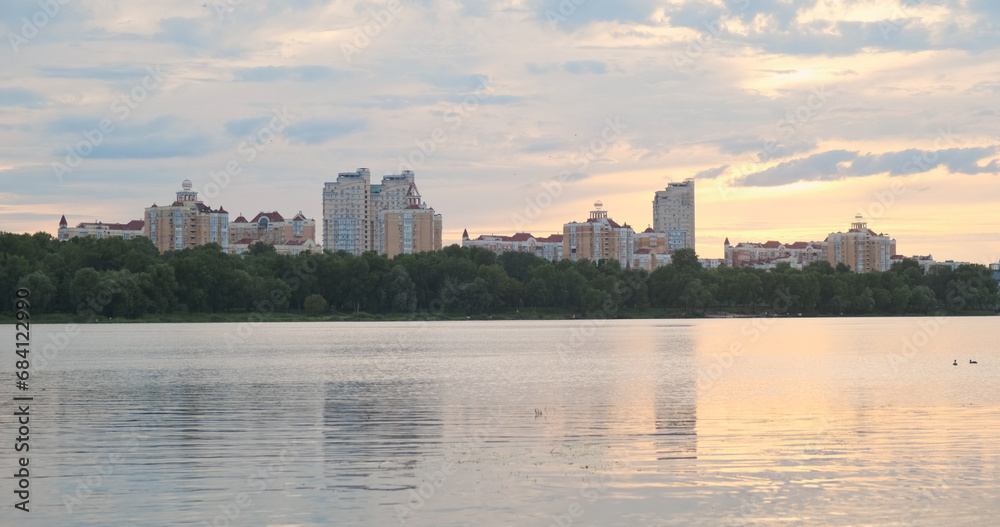 Sunset in big city. Clouds, river, water, buildings. Long video