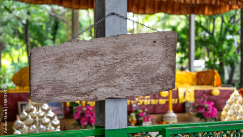 Image of a medium sized notice board Made from natural wood It is cut into rectangular sheets. There is a chain attached to the back. and was hung on a cement pole with nails driven into it photo