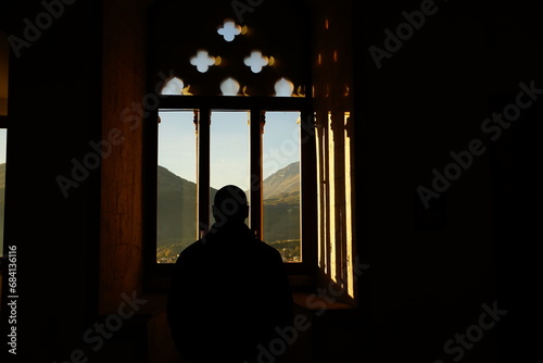 Silouette of a man looking at the mountains outside Celano Castle, L'Aquila, Abruzzo, Italy photo