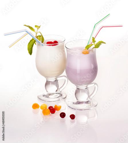 Two milkshakes in glass glasses on a white background. Raspberries and cranberries.