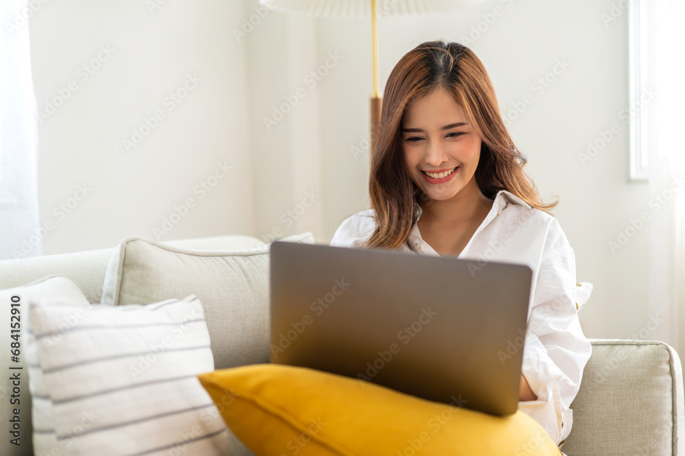 Young smiling asian woman happy relax use laptop conference work,learning, education, shopping, study online, webinar, online marketing, business, blog, digital internet advertising at home. Young smiling asian woman happy relax use laptop conference work,learning, education, shopping, study online, webinar, online marketing, business, blog, digital internet advertising at home.