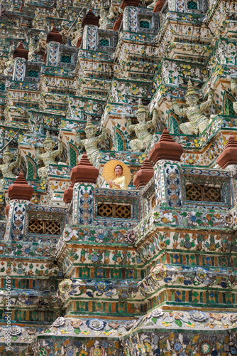 Asian tourists wearing the original traditional Thai costume Standing and taking pictures on the pagoda in Wat Arun Ratchawararam Ratchawaramahawihan. which is a popular tourist attraction in Bangkok,