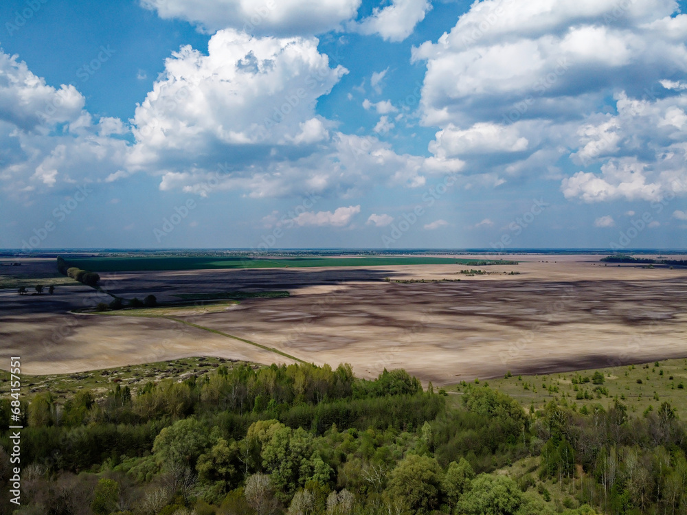 Beautiful blue sky over woodland, aerial view. Agricultural land.