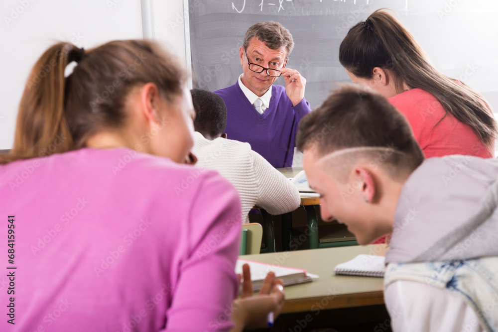 Obraz premium Professor watching as student write off on exams