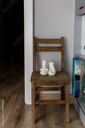 krzesło a na nim dziecięce skarpetki w białym kolorze w kształcie baranków. Koncept kobiety w ciąży i rychły czas przyjścia na świat dziecka. koncept problemów z ciąża, izolacja i problemy psychiczne
