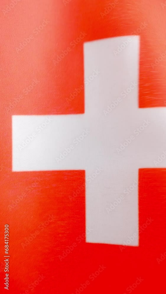 Vertical video of swiss national flag waving by the wind