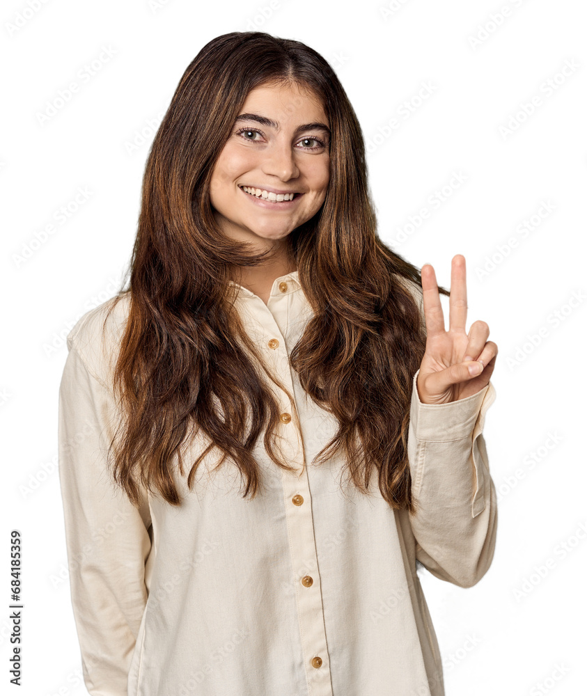 Young Caucasian woman in studio setting showing victory sign and smiling broadly. Young Caucasian woman in studio setting showing victory sign and smiling broadly.