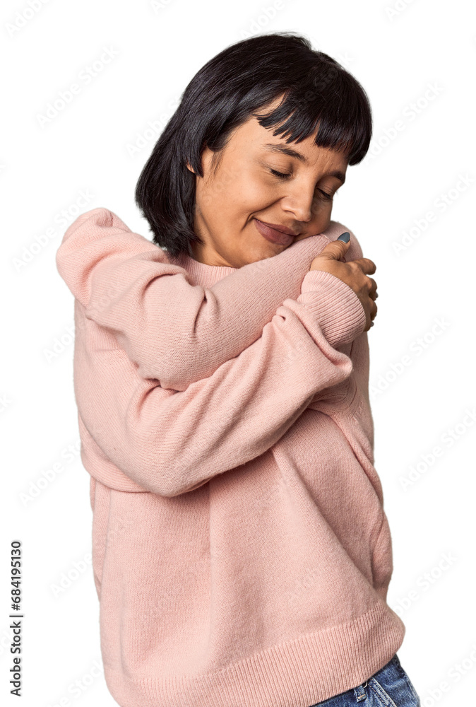 Young Hispanic woman with short black hair in studio hugs, smiling carefree and happy. Young Hispanic woman with short black hair in studio hugs, smiling carefree and happy.