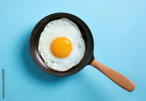 A fried egg in a frying pan on a blue background photo