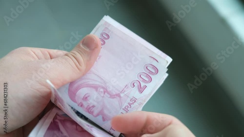 The man is counting Turkish banknotes in his hand. The concept of the Turkish economy.