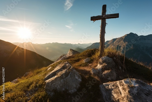 Wooden cross on the top of the mountain with clouds on the background