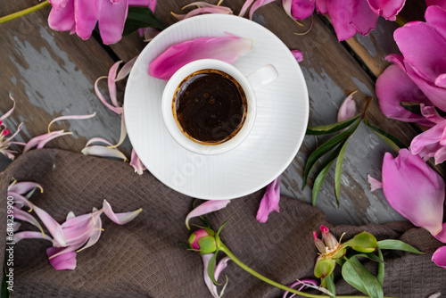 Pink peony flowers and a cup of coffee on a white background. Morninig, spring, fashion composition. Flat lay, top view, copy space. photo