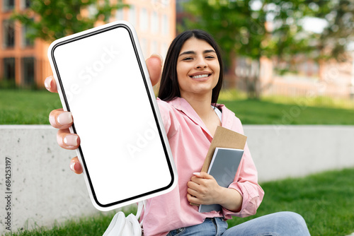 student lady showing large phone with empty screen outdoors © Prostock-studio