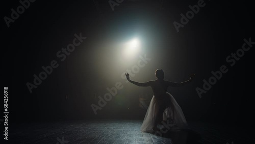 Ballet dancer reverence after performance. Silhouette of young ballerina on stage in spotlight
