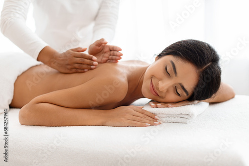 Relaxed indian woman having body massage at newest luxury spa.