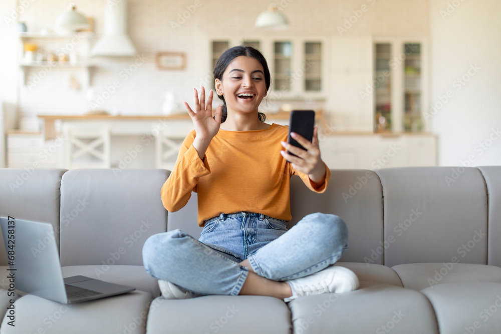 © Prostock-studio - Video Call. Happy Indian Woman Teleconferencing Via Smartphone At Home