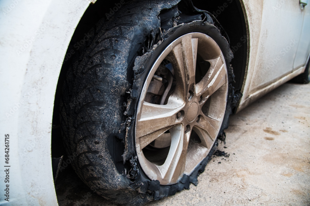 Flat and torn front left tire of the car in close-up Flat and torn front left tire of the car in close-up