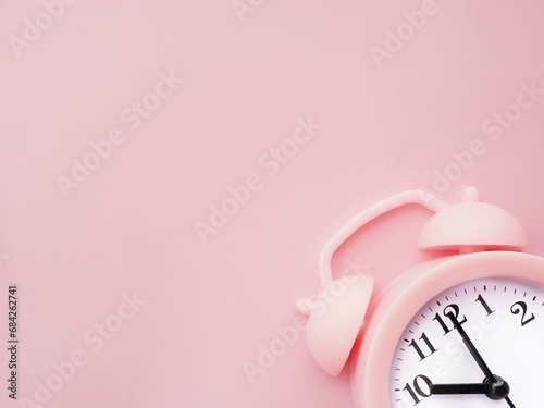 Pink background with alarm clock at 10am 10pm and copy space to add text 