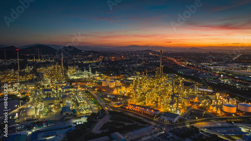 Aerial view of the morning of the oil refinery from the drone of the tower of the Petrochemistry industry in the oil​ and​ gas​ ​industry with​ cloud​ sun orange​ © chitsanupong