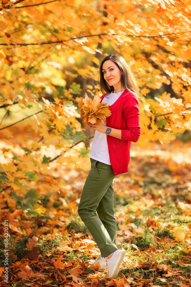 Portrait of happy woman with long hair playing with yellow autumn leaves in park during fall outdoor. Portrait of happy woman with long hair playing with yellow autumn leaves in park during fall outdoor.