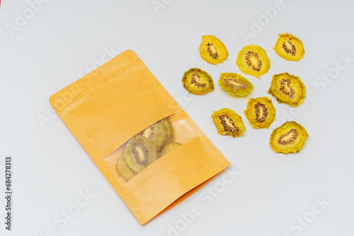 dried kiwi slices in a bag on a white background. kiwi dried in a dehydrator for preparing food and drinks. pear chips in a pack on a light background