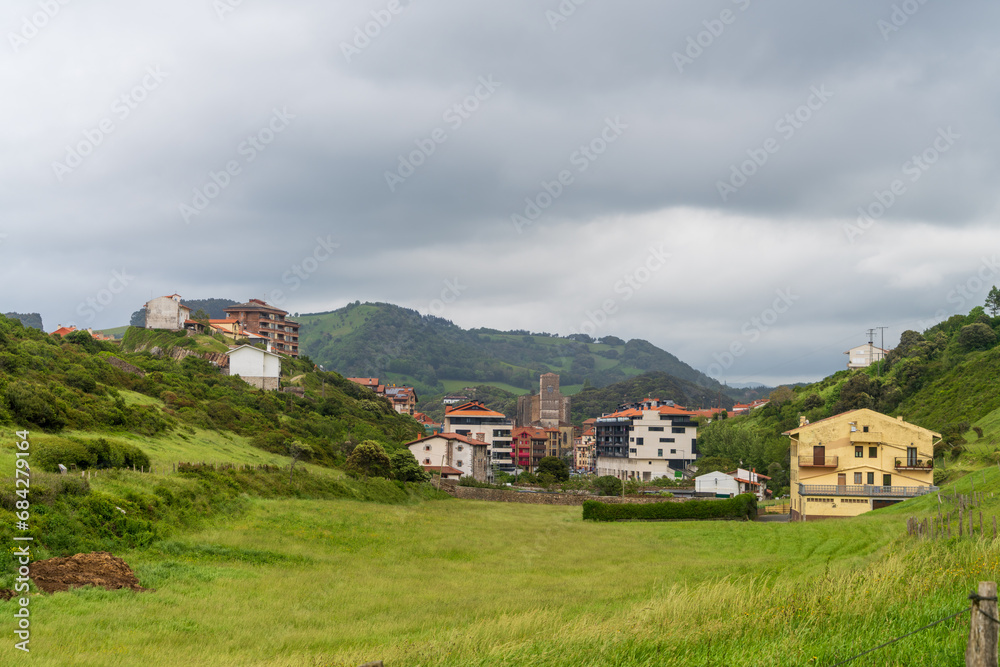 Fototapeta premium Zumaia is a small coastal town in Basque country, Spain. Seen here is a small part of the town and the surrounding hills under a slightly clouded sky