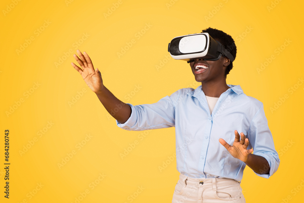 Smiling young african american woman student in casual and vr glasses, controls copy space
