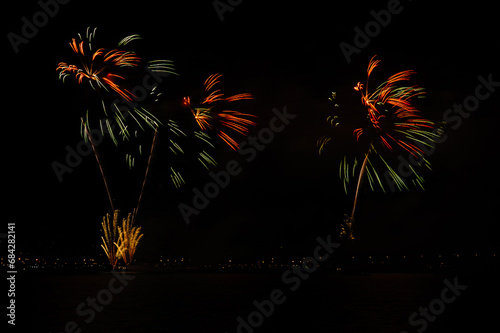 Fireworks explosions with shining sparks on dark background.