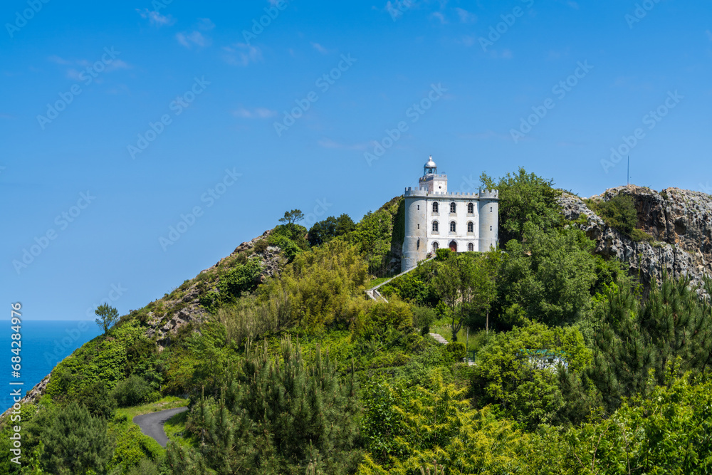Monte Ulia Mount with the Faro de La Plata lighthouse under a clear blue sky and the Cantabrian Sea in background Pasaia, Gipuzkoa, Basque country, Spain