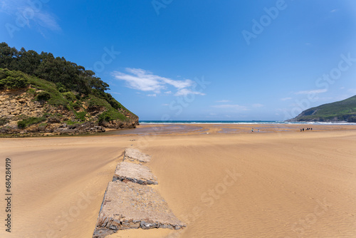 Playa La Arena in Pobeña under a blue sky where the river Barbadun flows into the Bay of Biscay, Basque country, Spain