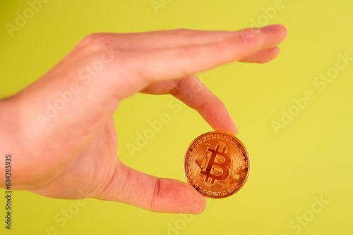 Bitcoin in the hand on a green background. Cryptocurrency.
