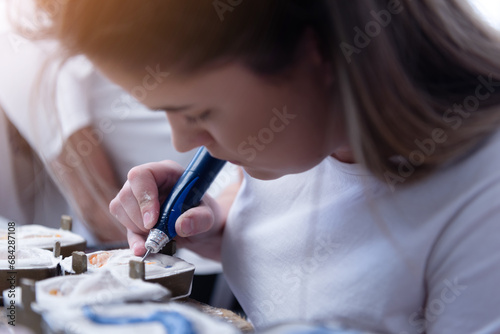 Dental technician working with tooth denture at prosthesis laboratory photo