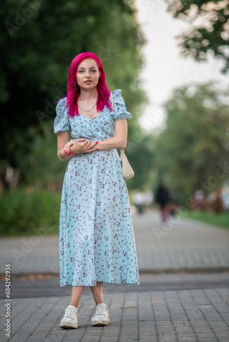 Portrait of a young beautiful girl with red hair in an urban environment.