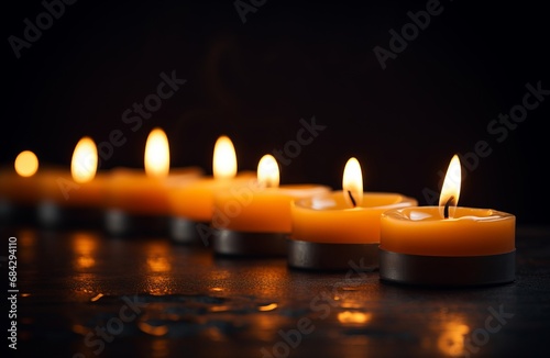 a row of burning candles with free space on dark background
