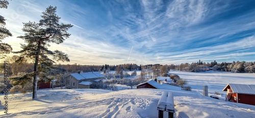 Scenic winter landscape featuring snow-covered houses and trees. Loppi, Finland photo