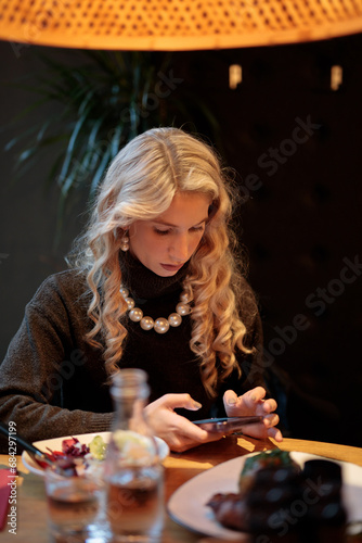 Woman in Black dress eating in restaurant