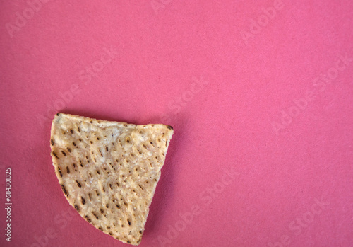 corn tortilla chips isolated on a pink red background (cut out masa chip for dipping) restaurant style crunchy toasted yellow, white nixtamalized hominy (mexican food, totopos) photo