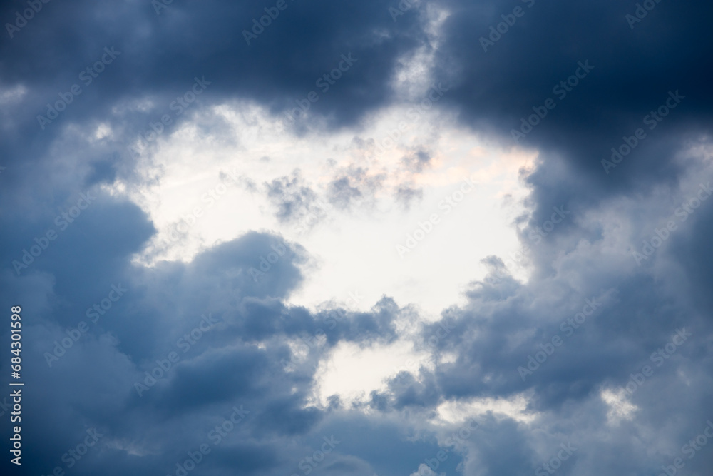 Hole in clouds - stormy weather background