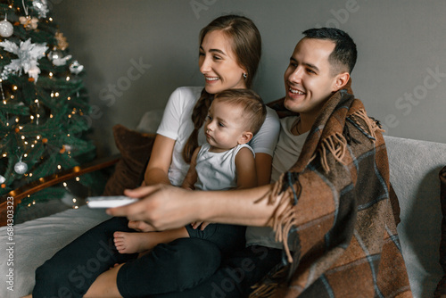 Obraz na płótnie A family of young parents and son cherishes moments together over Christmas holidays