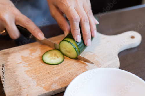Slicing fresh cucumber close-up