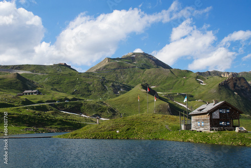 lake in the mountains of austria with a small cabin at the großglockner hochalpenstraße