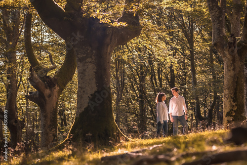Casual couple strolling along a green forest